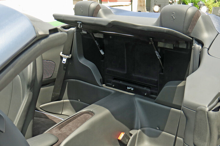 新開発のウインドディフレクターは、後席の背もたれを写真のように展開する仕組みとなっている。以前の2＋2オープンモデルと比べて、前席乗員の頭部周囲に発生する乱流の抑制効果が、約30％向上している。（写真：webCG）