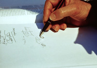 来場者の求めに応じてサインをするオプロン氏。なにやらオーバルシェイプのクルマを描いている。本人のサービス精神をみた。