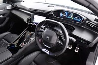 上端下端がフラットになった小径ステアリングホイールと、そのリム越しに見るメーターパネルが特徴的なコックピット。センターコンソールは若干ドライバー側に傾けられている。