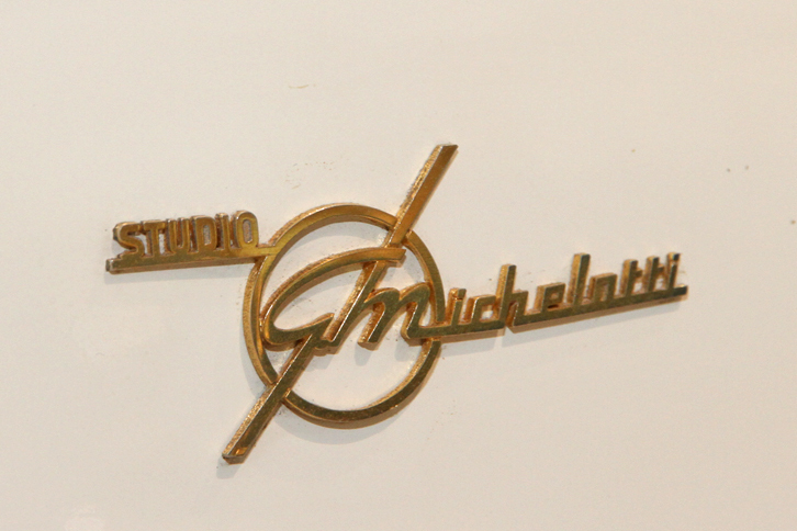 「コンバーチブル」のフロントフェンダー前端に貼られた、スタジオ・ミケロッティのエンブレム。プロトタイプ完成当時の写真を見た限りでは、このエンブレムは「クーペ」だけに付けられている。だが現在はクーペからは失われ、コンバーチブルには付いている。生産車には双方とも付いているので、その部品を貼ったのかもしれない。