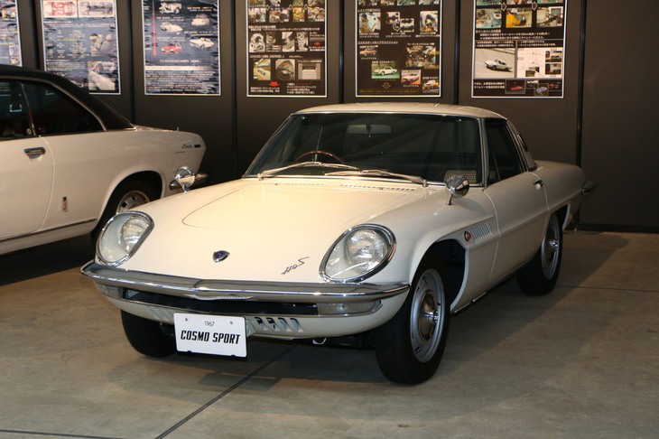 「コスモスポーツ」。1967年にデビューしたマツダ初のロータリーエンジン搭載車。展示車はショートホイールベースの前期型。デビュー翌年の1967年の改良によってホイールベースを延長した後期型となるので、前期型はかなりレア。フロントマスクのデザインなど各部の仕様も異なる。