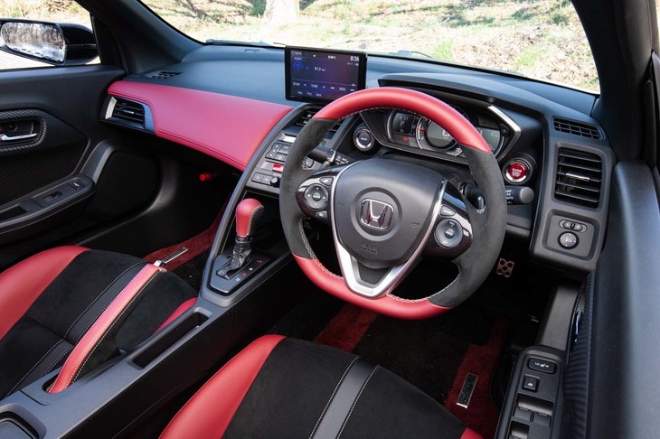 インテリアはボルドーレッドとブラックで大胆にコーディネート。着座位置の低さが印象的だ。