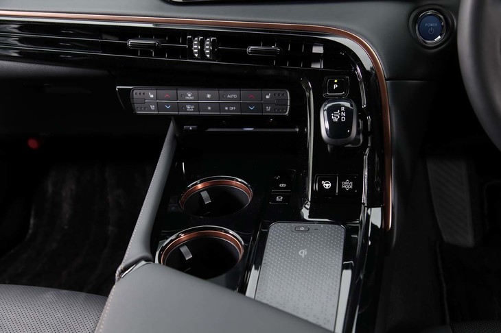 カッパーの加飾が施されたセンターコンソールには、カップホルダーやスマートフォンの非接触充電トレイが並ぶ。