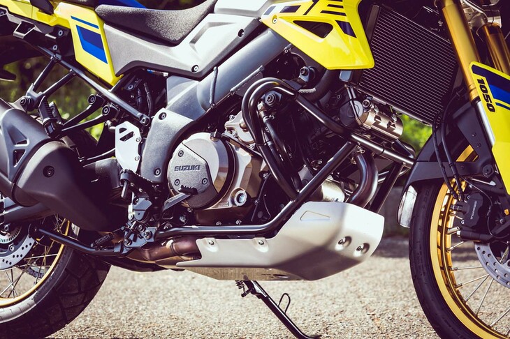 アルミ製のエンジンプロテクターでガードされた「Vストローム1050DE」のエンジン。挟み角90°、排気量1036ccのV型2気筒DOHCで、Vツインならではの鼓動感とパワフルなフィーリングを実現。また低中回転域のトルクの太さと高回転域での伸びのよさを両立している。