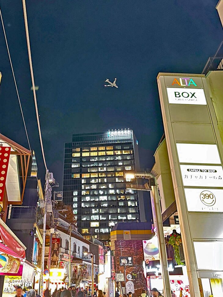 原宿・竹下通りの上空を飛ぶ旅客機。2023年11月撮影。