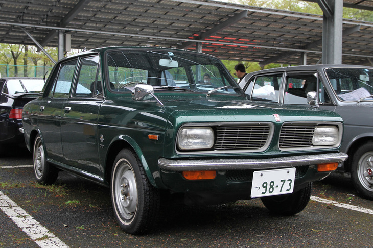 1969年「ホンダ1300 77デラックス」。H1300の基本形であるセダンの77（セブンティセブン）。他社の1.8～2リッター級に匹敵する最高出力100psという驚異的な高出力を誇るDDACエンジンを搭載し、しかもこのデラックスで56万8000円という低価格（ちなみにボディーサイズが近いがエンジンは小さい「カローラ1100 4ドアデラックス」は52万6500円、排気量は同じだがボディーは大きい「ブルーバード1300 4ドアデラックス」は62万4000円）。ホンダは発売から半年以内に月産1万台ラインにもっていくと豪語していたが……。