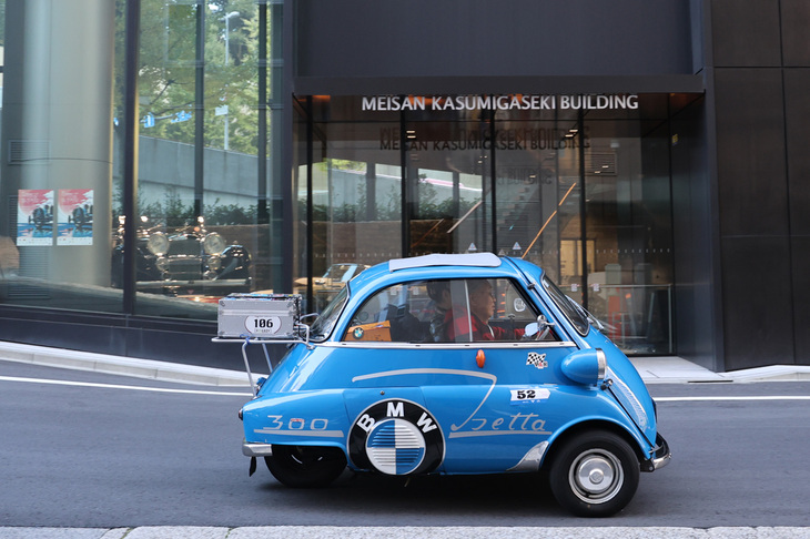 最後のチェックポイント兼スタンプポイントが置かれた、アルヴィス霞が関ショールームの前を通過する1961年「BMWイセッタ ブライトン」。