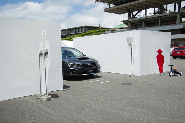 「レヴォーグ」によるフロントビューモニターの体験試乗の様子。写真の状態（車両前端がT字路の1m手前にある段階）ですでに、モニターには歩行者や三輪車などが表示されている。