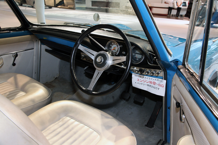 こちらは「クーペ」のインテリア。メーターの配置はコンバーチブルと同じだが、盤面のデザインや針は微妙に異なる。ステアリングホイールはコンバーチブルと同じだが、リムに革製カバーを装着。こちらの本革張りシートはオリジナルと思われる。ドア内張に付けられたウィンドウレギュレーターの位置が、コンバーチブルとは異なることに注目。プロトタイプの製作期間は約半年で、トリノショー当日の朝にようやく仕上がったという突貫工事だったため、2台のディテールには異なる部分が少なくない。