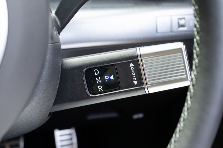 シフトセレクターはステアリングコラムに備わっている（意外に大きい）。シルバーの部分を前に回すとD、後ろに回すとRに入るというロジックは、一般的なATセレクターとは逆になっている。