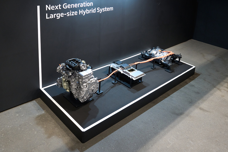 中央にあるのは大型のハイブリッド用バッテリー。妙に厚みがあるのはラダーフレームの間にぶら下げて搭載するような想定だからとのこと。