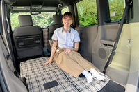 「ホンダN-BOXジョイ」は、後席をたためばチェック柄のフロアが広がるくつろぎの大空間が出現！ 座り心地がいいよう、後席背面にプレートを仕込むというこだわりようだ。写真はチェック柄のインテリアを考案した、本田技術研究所の松村美月氏。（写真：向後一宏）