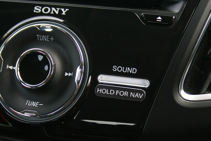 横長の「SOUND」ボタンの下に貼られた「HOLD FOR NAV」というシールが、ナビ装着車であることを知らせる。このボタンを長押し（4～5秒）すると、ナビとSYNCが切り替わる。