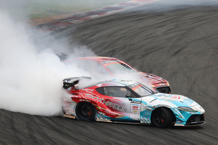 追走では、前後の車両を入れ替える先行と後追いの2回が行われる。先行時には、自分のベストなドリフト走行を見せ、後追い時には、先行する車両に合わせたドリフトが求められる。激しいタイヤスモークにも見舞われる後追い走行は、視界も悪くなるため、ドライバーとしての高い判断力も求められるのだ。写真は、先行の「GRスープラ」山中選手と後追いの「インフィニティQ60」蕎麦切広大選手のバトル。