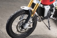 ゴールドの倒立フォークが目を引くフロントまわり。タイヤはダート走行にも対応するピレリの「スコーピオン ラリーSTR」で、ブレンボが主に新興国の小中排気量車向けに展開しているBYBRE（バイブレ）ブランドのブレーキキャリパーが採用されている。