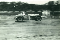 多摩川スピードウェイを走る「カーチス号」。当時は走行中の故障やパンクに備え、ドライバーに加えてライディングメカニックが乗車するのが通例だった。（写真：多摩川スピードウェイの会）