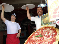 店主のヨルダン人アシュラフさん（右）と店員の二ダールさん（左）。回しているのは、練習用のシリコン製ピザ生地ダミー。