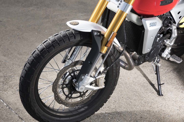 ゴールドの倒立フォークが目を引くフロントまわり。タイヤはダート走行にも対応するピレリの「スコーピオン ラリーSTR」で、ブレンボが主に新興国の小中排気量車向けに展開しているBYBRE（バイブレ）ブランドのブレーキキャリパーが採用されている。