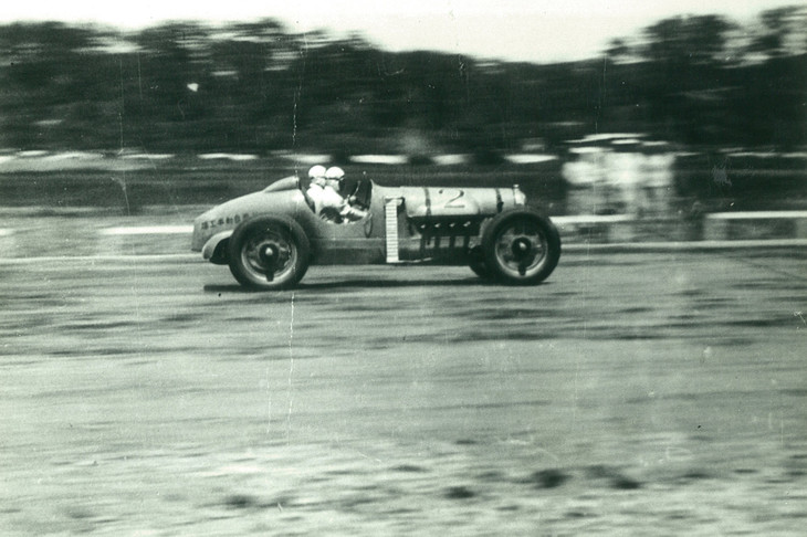 多摩川スピードウェイを走る「カーチス号」。当時は走行中の故障やパンクに備え、ドライバーに加えてライディングメカニックが乗車するのが通例だった。（写真：多摩川スピードウェイの会）