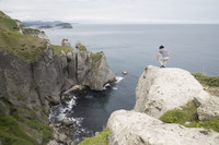 トッカリショ岬から崖下をのぞき込む筆者。特に柵などは設けられておらず、他の観光客も同じようにしていたが、もしも訪れる場合は十分に注意されたし。