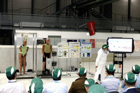 歩行者ダミー開発の歴史を紹介するホンダのスタッフ。ホンダでは1988年に歩行者保護の研究を開始。既存のインパクタ（頭部や脚部を模した球状や棒状のダミー）では人体への影響を正確に再現できないことから、歩行者ダミーの自社開発に着手した。