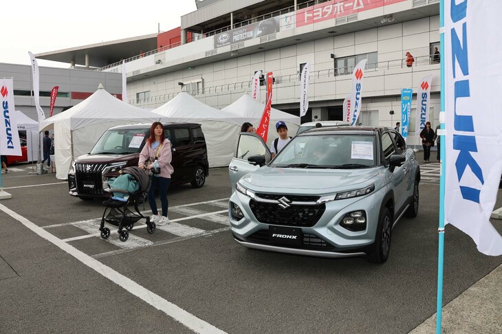 スズキは人気の小型SUV「フロンクス」などの新車展示に加え、公式グッズの販売も実施。オンラインでも販売されているが、製品を目で確認して購入できる貴重な機会とあって、熱心にグッズを選ぶファンでにぎわっていた。