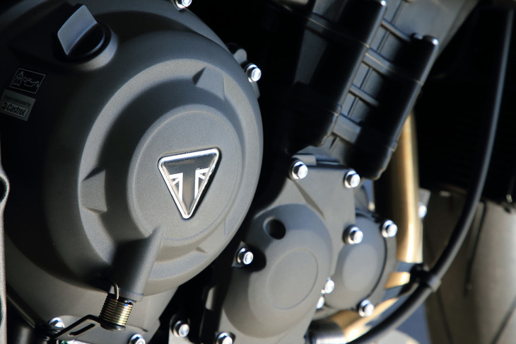 トライアンフのバッジが貼られたトランスミッションケース。新型「ストリートトリプルRS」のトランスミッションは、従来型より1速、2速がクロスされているほか、工作精度を高めることでバックラッシュ防止ギアを省略して軽量化。スリップアシストクラッチやシフトアップ／ダウンの両方に使用できるクイックシフターが標準装備される。