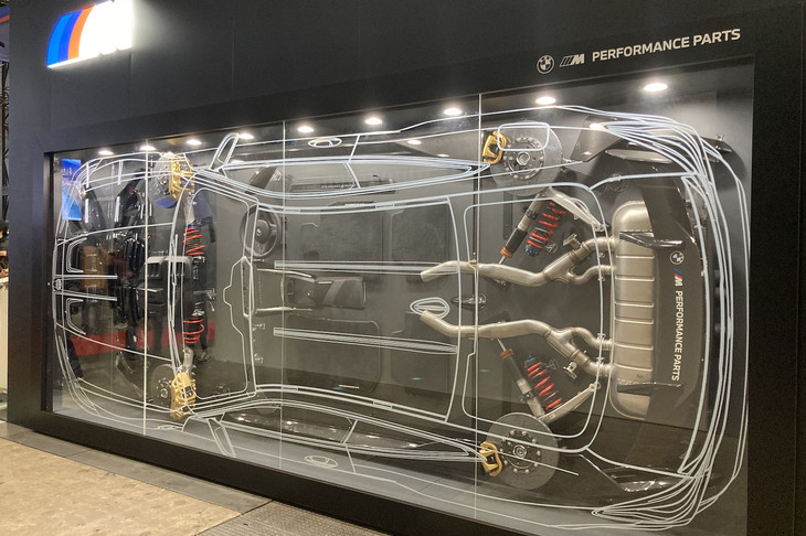 ブースの壁にディスプレイされた「Mパフォーマンスパーツ」の巨大なジオラマ。
