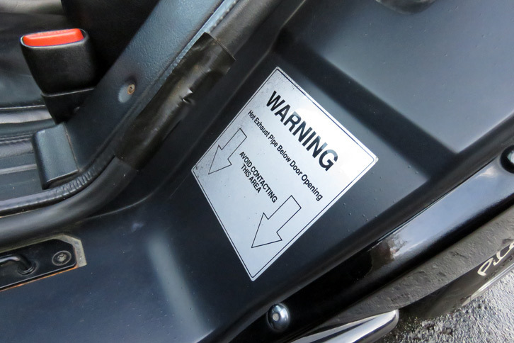 極太のドアシルにはこんな注意書きが。いわく「ホカホカのエキゾーストパイプが下を通っているから、ここに触っちゃだめだぜ！」。……注意書きを書く前に、やることがある気がするのだが。