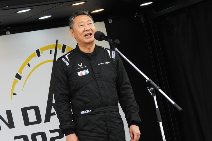 パドックのステージにて、イベント開始のあいさつをするゼネラルモーターズ・ジャパンの若松 格社長。毎年恒例、黒のレーシングスーツでの登壇である。