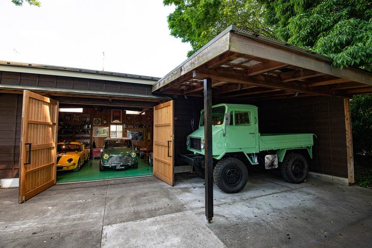 大きな扉が特徴的なガレージ。傍らにはウニモグのコピーともいわれる三菱2W400がすむ。