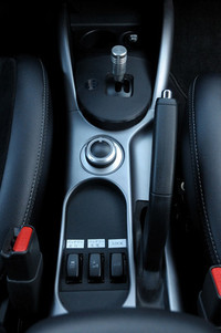 トランスミッションを持たないため、シフトレバーは前進／後退を切り替えるためのごく小さなもの。センターコンソールに備わるダイヤルで、「ECO」「ノーマル」「パワー」の3つのモーターを切り替える。その後ろにあるボタンは、左から「バッテリー走行モード」「バッテリー充電モード」「ロック」となっている。「ロック」はハイブリッドシステムとは関係なく、悪路を走行するためのスイッチ。