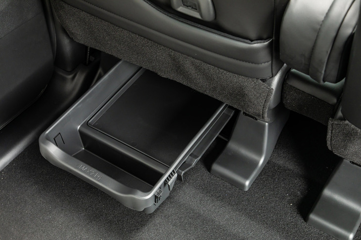 助手席シートアンダートレイは、前側にはもちろん後ろ側にも引き出して使えるスグレモノ。車検証入れをきれいにしまえるよう仕切られた内部の形状は、「デリカミニ」でも受け継がれるようだ。（車検証は2023年1月からICカード化される）