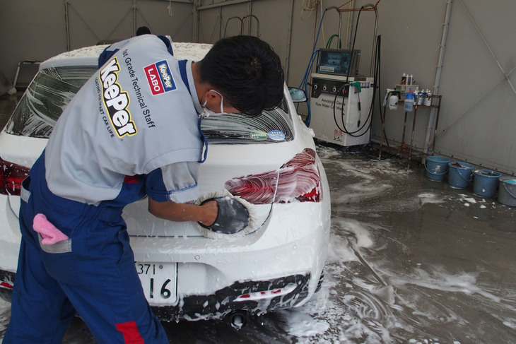 ボディー洗浄の様子。パネル1枚ずつ丁寧に、しかもスピーディーに作業が行われる。その動きには無駄がなく、まさに職人技。ボディー下部と上部でモップが使い分けられるなど、クルマへの負担を最小限にするさまざまな工夫が施されている。