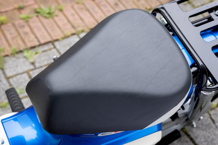 三角形のシンプルなシートは、純正アクセサリーでさまざまにカスタマイズ可能。燃料タンクはこの下にあり、シートを前方に跳ね上げて給油する。