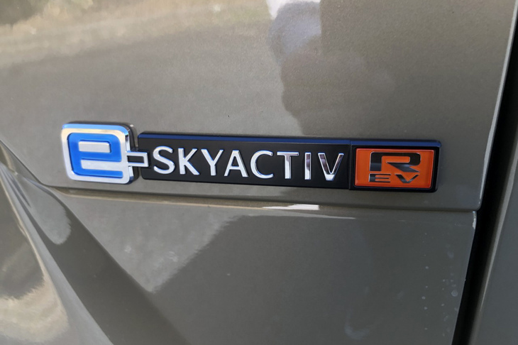 「MX-30ロータリーEV」のリアに備わるエンブレム。独自のシリーズ式プラグインハイブリッドシステムの搭載を主張している。