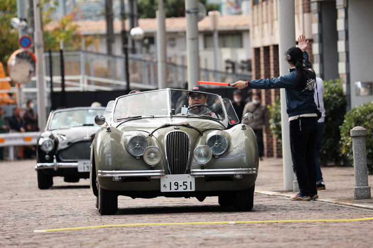 線路沿いの道では、計時センサーが仕込まれたケーブルをタイヤで踏むことから、俗に“線踏み”と呼ばれるPC競技を実施。オフィシャルの指示にしたがって競技に臨む1951年「ジャガーXK120」。続くのは1959年「アストンマーティンDB2/4 Mk3ドロップヘッドクーペ」。