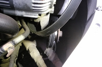 後日、コレクションズ本多氏より送られてきたエンジンルーム内の写真。ベルト、完全に外れとるやんけ！ おかしいなあ、自分で見たときは、かかっているように見えたんだけど……。ちなみに、奥の方に、今回のトラブルの原因となったテンションプーリー（だったもの）が写っている。