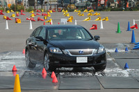 濡れたゴムマットの上を走り、横滑り防止装置の効果を確認する、の図。システムが比較的早めに介入するレクサス車は、見ても乗っても、ライバルのドイツ車よりも挙動の乱れが小さい。