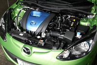 30km/リッター（10・15モード値）のキーとなる、「スカイアクティブG 1.3」ユニット。専用の青いエンジンカバーが、特別なエンジンの目印だ。