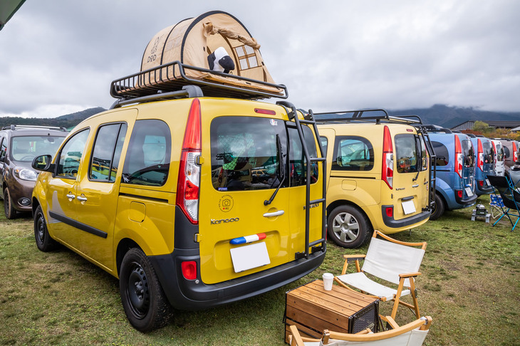 純正オプションの「トリコロールセレクション：リアライセンスプレートランプカバー」を装着した「カングー」。そのルーフキャリアに備わるテントの中から誰かが外をのぞいている。