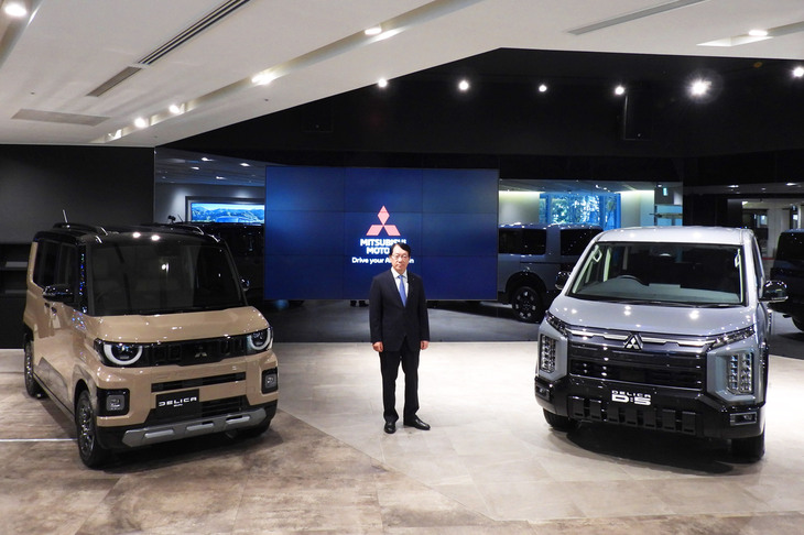三菱の加藤社長と、写真右が「デリカD：5」、同左が「デリカミニ」。