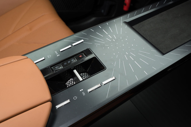 放射状のモチーフが目を引くセンターコンソールには、シフトセレクターやドライブモードの切り替えボタン、オーディオ音量などのスイッチを配置。スマートフォン用のワイヤレスチャージャーやUSB Type-Cポート（2口）も備わる。