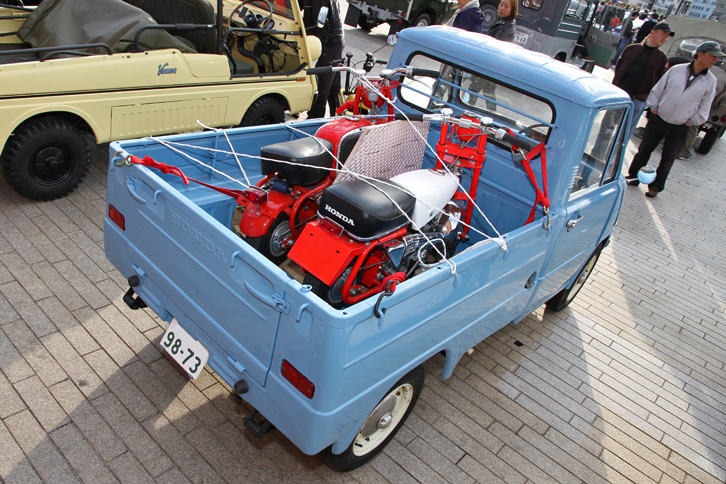 1963年に発売されたホンダ初の市販四輪車であり、日本初のDOHCエンジン搭載車だった軽トラックの「ホンダT360」。荷台に積まれているのは、生産終了が話題となった「モンキー」のルーツとなる2台。右側はホンダが1961年にオープンしたモータースポーツ施設である多摩テックの遊具用として作られた「Z100」のレプリカで、左側は1963年に輸出専用として登場した最初の市販型である「CZ100」。