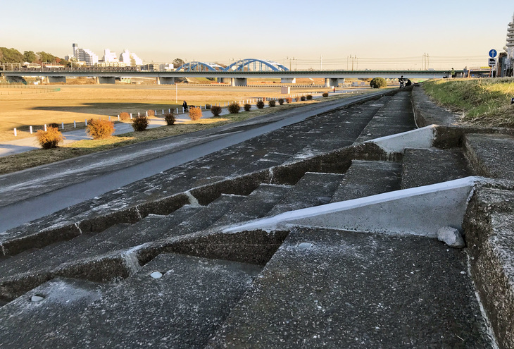 破損した部分は補修されているものの、85年前の竣工（しゅんこう）当時のままの姿を残すコンクリート製の観客席。見下ろす河川敷に全長約1200mの簡易舗装されたオーバルコースが存在した。