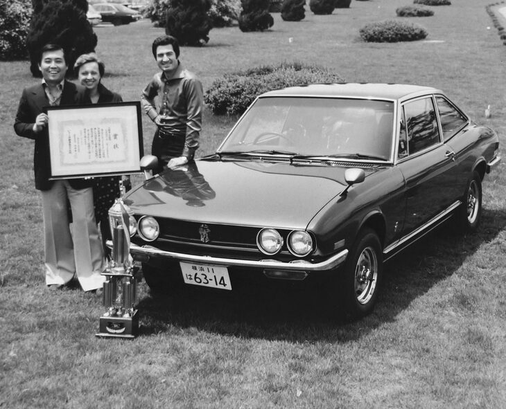 いすゞ藤沢工場で、「117クーペ」と宮川、マリーザ、ジウジアーロの各氏。1972年頃。（出典：日本自動車殿堂）