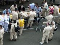 ピットにあらわれた、ベージュ色の男たち。その正体は……