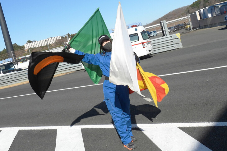 笑顔で4本の旗を振る、剛腕なオフィシャルスタッフ。笑顔で「旗振りならだれにも負けません！」と宣言していた。