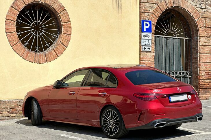 2023年9月シエナで。ポーランドのナンバーを掲げた「メルセデス・ベンツCクラス」。赤のメタリックという塗色も、このクラスのクルマを買うイタリア人の間では、あまり見られない選択である。