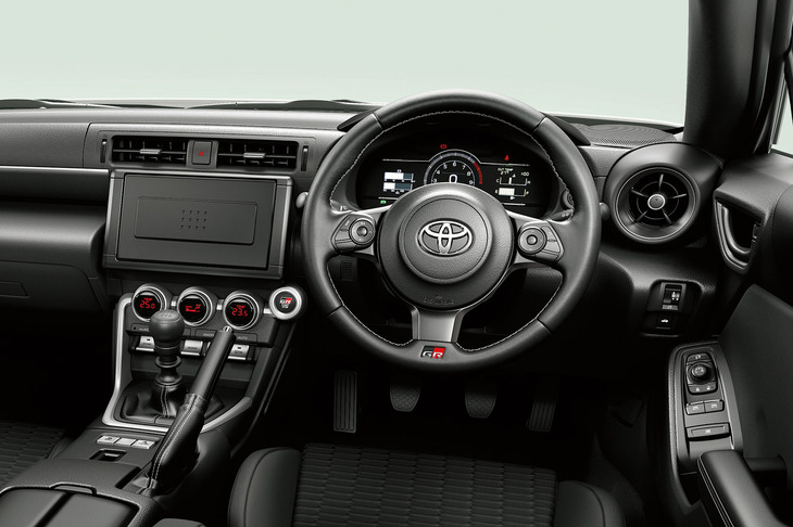 「トヨタGR86 RC」の運転席まわり。ステアリングホイールは革巻きだが、シフトレバーとパーキングブレーキレバーはウレタン製に。またスピーカーからエンジン音を発生する「アクティブサウンドコントロール」も省かれる。